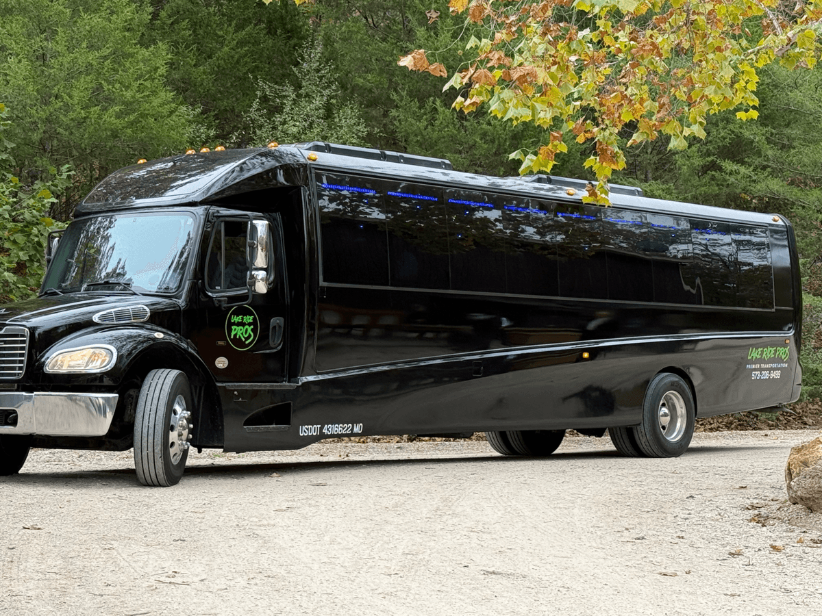 Lake Ride Pros Executive Shuttle Bus parked along a tree-lined drive